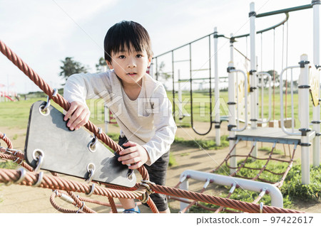 5 歲男孩在遊樂場設備上玩耍 97422617