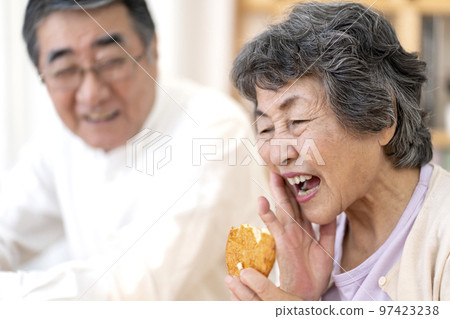 Senior woman who finds it difficult to eat hard food Senior woman who finds it difficult to eat hard food 97423238
