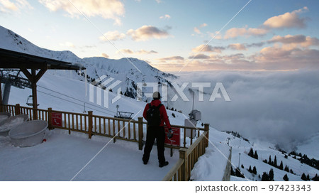 The guy is standing on the playground in mountains 97423343