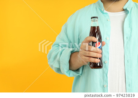 Concept of people, fat man with bottle of Pepsi on yellow background 97423819