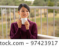 Woman relaxing on hotel terrace 97423917
