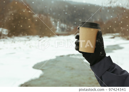 Female hand holding blank paper cup outdoor 97424341