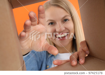 Concept of delivery, surprise, gift, young woman opened a cardboard box Concept of delivery, surprise, gift, young woman opened a cardboard box 97425178