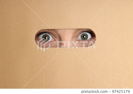 Concept of delivery, surprise, gift, female eyes and cardboard box Concept of delivery, surprise, gift, female eyes and cardboard box 97425179