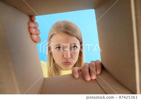 Concept of delivery, surprise, gift, young woman opened a cardboard box Concept of delivery, surprise, gift, young woman opened a cardboard box 97425361