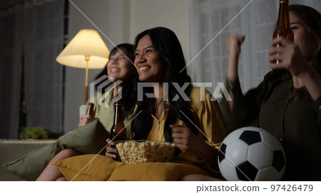 Holiday concept of 4k Resolution. A group of Asian women watching a soccer match broadcast together at home. Fun and exciting leisure activities. Holiday concept of 4k Resolution. A group of Asian women watching a soccer match broadcast together at home. Fun and exciting leisure activities. 97426479