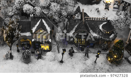Toy Christmas eve town, old city covered with snow. Dark creepy spooky black houses with light in windows, people, top view 97427328