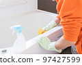 Middle-aged man cleaning the bathtub in the bathroom 97427599