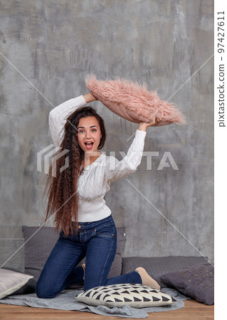 Young pretty attractive brunette woman posing before camera sitting on the floor 97427611