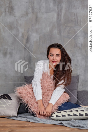 Young pretty attractive brunette woman posing before camera sitting on the floor 97427624