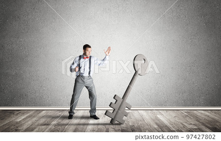 Breaking through access concept with man in room crashing concrete key 97427802
