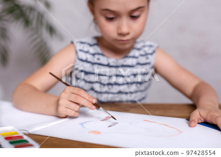 Inspired little girl at the table draw with paints 97428554