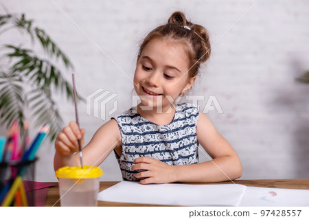 Inspired little girl at the table draw with paints 97428557