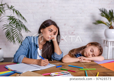 Mother becoming frustrated with daughter whilst doing homework sitting at the table at home in learning difficulties homework. 97428573