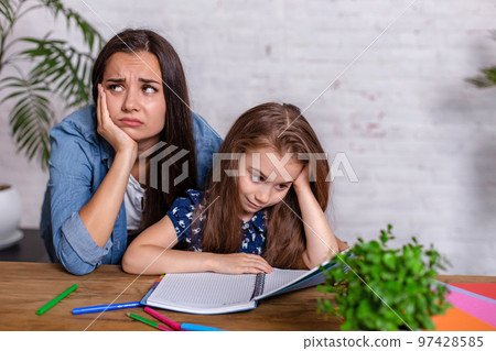 Mother becoming frustrated with daughter whilst doing homework sitting at the table at home in learning difficulties homework. 97428585