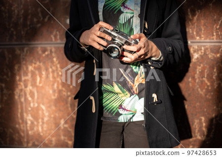 Girl photographer with an old camera in his hands. Girl photographer with an old camera in his hands. 97428653