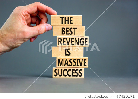 Revenge or success symbol. Concept words The best revenge is massive success on wooden blocks. Bussinesman hand. Beautiful grey background. Business and revenge or success concept. Copy space. 97429171