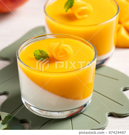 Delicious double colored mango panna cotta mousse pudding on wooden table background. 97429497