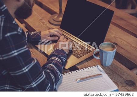 Cropped image of young man chatting via net-book during work bre Cropped image of young man chatting via net-book during work bre 97429668