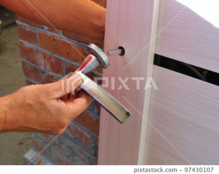 installing a door handle, threading the handle onto a pin in the door leaf, assembling the door lock mechanism 97430107