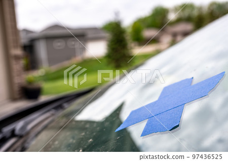 Tape covering a chip on a car windshield. Tape covering a chip on a car windshield. 97436525