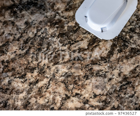 Ant trap poison bate on a granite kitchen countertop 97436527
