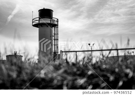 Defocused foreground with industrial emergency flare standing out against an open sky 97436552