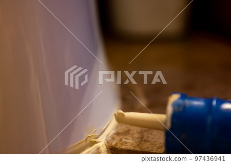 Selective focus on silicone caulking ready to be applied around the seal of a bathroom toilet. Selective focus on silicone caulking ready to be applied around the seal of a bathroom toilet. 97436941