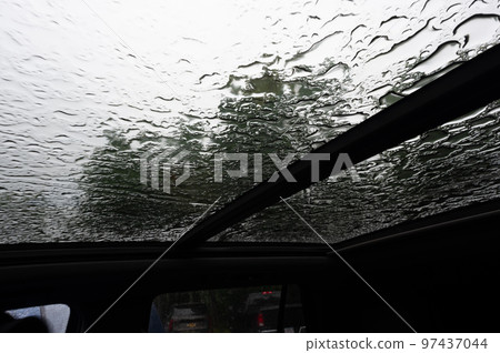 Inside a vehicle looking up to a sunroof with water droplets Inside a vehicle looking up to a sunroof with water droplets 97437044