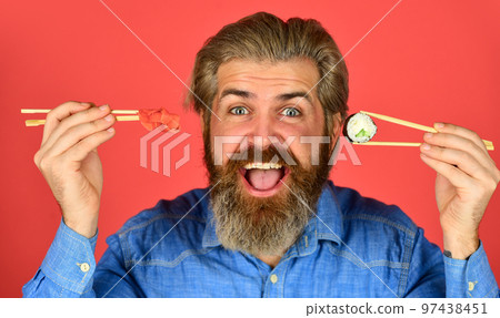 sushi roll dish take away. Sushi delivery. happy man eat sushi. sushi and ginger with chopsticks. Japanese cuisine. Traditional food in Japan. Chief meal Fast service. asian meal 97438451