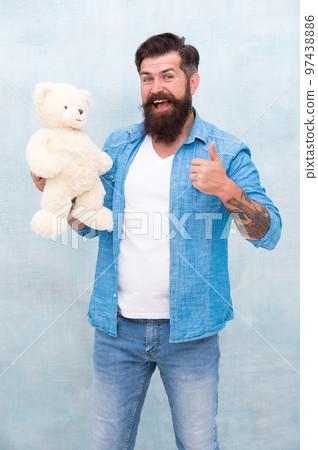 Happy birthday. Handsome hipster hold lovely bear toy. Caring and loving guy. Valentines day. Present for your partner. Man with beard happy face carry gift toy. Playful mood. Toys shop concept 97438886