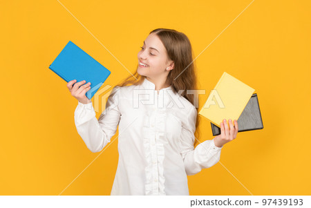 cheerful child showing school book on yellow background, back to school cheerful child showing school book on yellow background, back to school 97439193