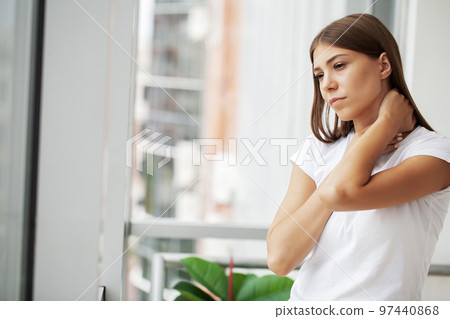 Brunette woman has neck pain in the office Brunette woman has neck pain in the office 97440868