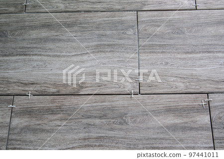 Laying ceramic tiles using plastic crosses. Renovation or repair concept 97441011