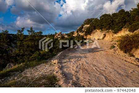 Sandy mountain road of the island of Cyprus in the light of the setting sun. Sandy mountain road of the island of Cyprus in the light of the setting sun. 97442048