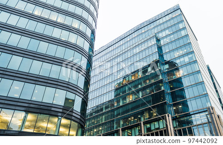 Large glass windows of a modern business center in cloudy weather. Large glass windows of a modern business center in cloudy weather. 97442092