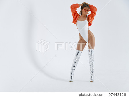 A beautiful girl of an athletic physique erotic moves in front of the camera, she is dressed in high boots of silver color, white bodysuit, pink jacket and glasses, long brown hair, white background A beautiful girl of an athletic physique erotic moves in front of the camera, she is dressed in high boots of silver color, white bodysuit, pink jacket and glasses, long brown hair, white background 97442126