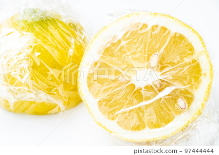 檸檬切成兩半並用保鮮膜包裹。 (白色背景) 檸檬切成兩半並用保鮮膜包裹。 (白色背景) 97444444