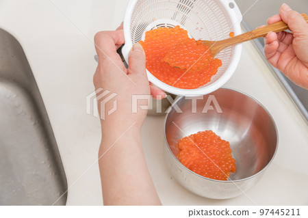 [Transfer raw salmon roe soaked in sake to a bowl to make soy sauce marinated salmon roe] 97445211