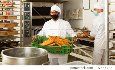 male baker in mask with sesame bread in black box in kitchen 97445788