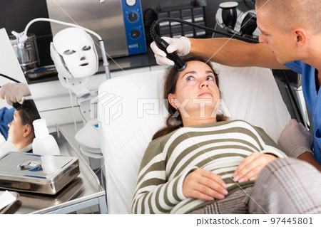 Woman during face ultrasound lifting procedure Woman during face ultrasound lifting procedure 97445801