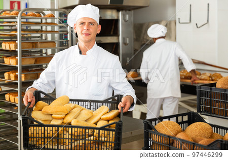 man in chefs uniform with bread in tray in bakery man in chefs uniform with bread in tray in bakery 97446299