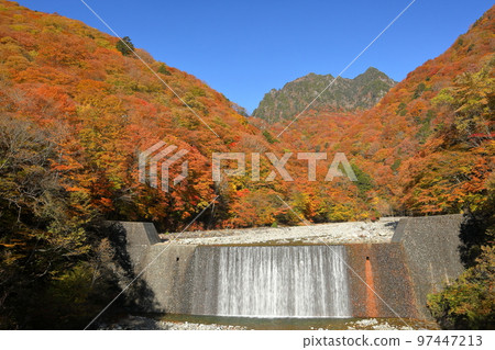 山梨縣山梨市三富川浦,西澤溪谷二俁吊橋秋葉環繞的防侵蝕壩瀑布和背景中的慶函山 山梨縣山梨市三富川浦,西澤溪谷二俁吊橋秋葉環繞的防侵蝕壩瀑布和背景中的慶函山 97447213