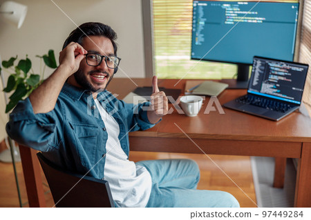 Male freelancer making new project as web designer or programmer on his computer at home office Male freelancer making new project as web designer or programmer on his computer at home office 97449284