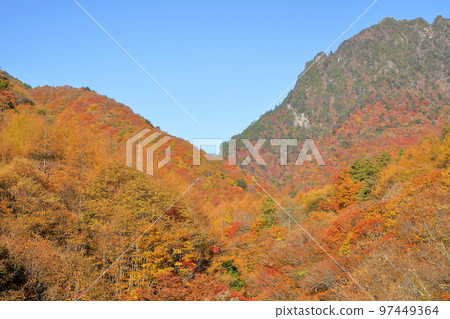 山梨縣山梨市從西澤溪谷步道看到的山上的秋葉和背景中的慶函山 97449364