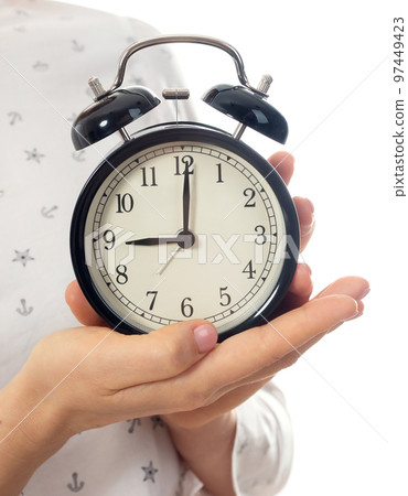 Woman hands holding black alarm clock Woman hands holding black alarm clock 97449423