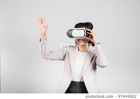 Smiling woman confidence excited wear VR headset device touching air during virtual reality experience isolated white background, Asian happy portrait female playing video game studio shot, copy space 97449982
