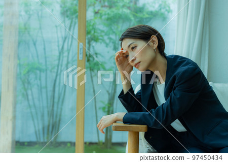 A businesswoman by the window in the rain 97450434