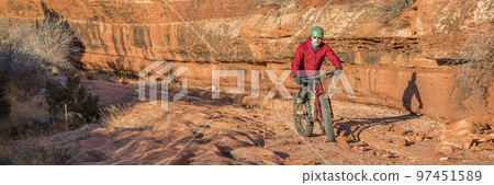 riding fat bike on slickrock at  canyon bottom 97451589