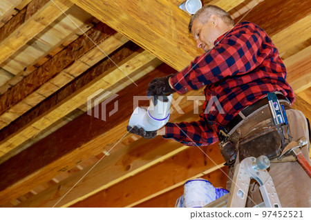 An experienced plumber joins plastic pipes by using cement glue on PVC pipe as part of construction process residential home 97452521